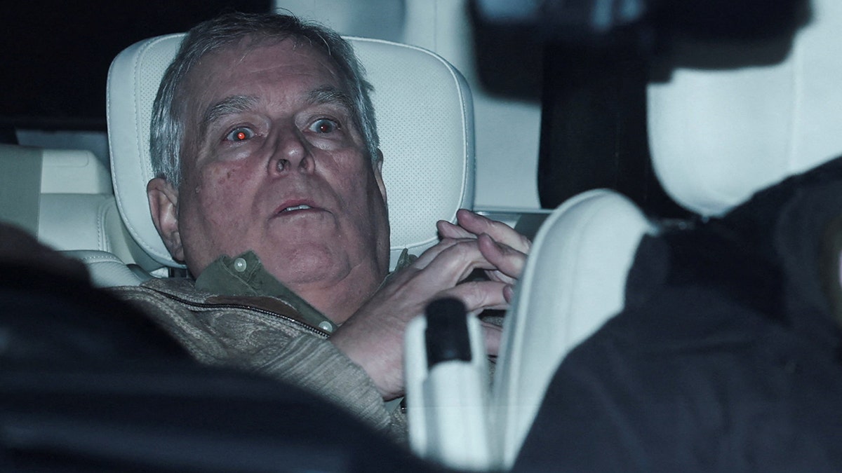 Andrew Mountbatten Windsor seated in a vehicle leaving Aylsham Police Station.