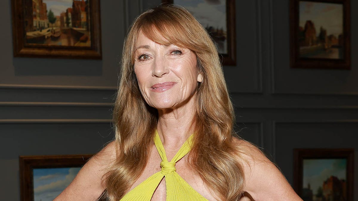 Jane Seymour smiling and wearing a yellow dress at an event.