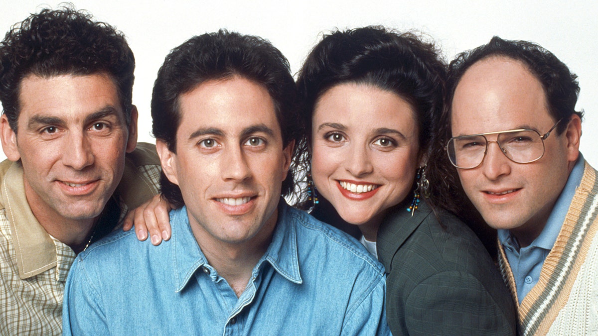 Michael Richards as Cosmo Kramer, Jerry Seinfeld as Jerry Seinfeld, Julia Louis-Dreyfus as Elaine Benes, and Jason Alexander as George Costanza squeezing together