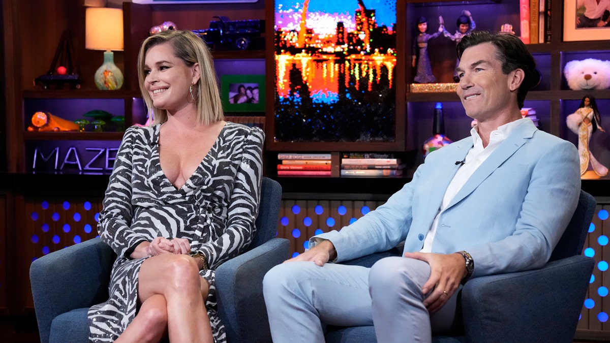 Rebecca Romijn and Jerry O'Connell sitting on a Bravo show set.